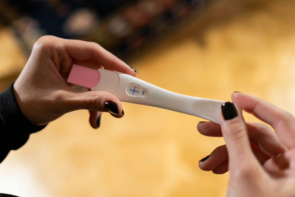 pexels-photo-6473742-6473742 Closeup of hands holding a positive pregnancy test with a cross symbol.